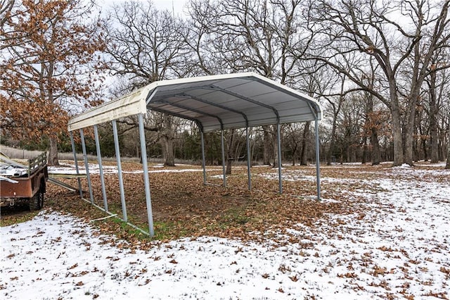 snow covered parking featuring a carport