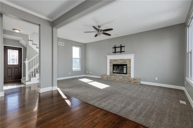 unfurnished living room with dark hardwood / wood-style flooring, ornamental molding, ceiling fan, and a fireplace