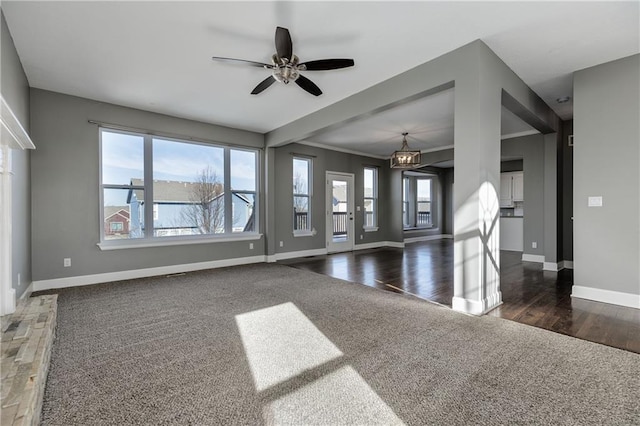 unfurnished living room with plenty of natural light, dark hardwood / wood-style floors, and ceiling fan