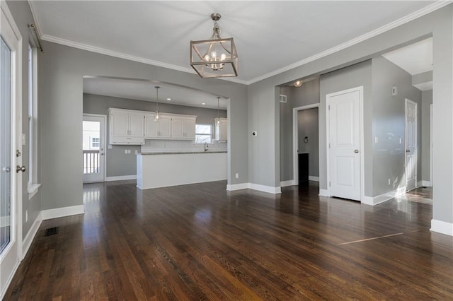 unfurnished living room featuring ornamental molding, an inviting chandelier, and dark hardwood / wood-style flooring