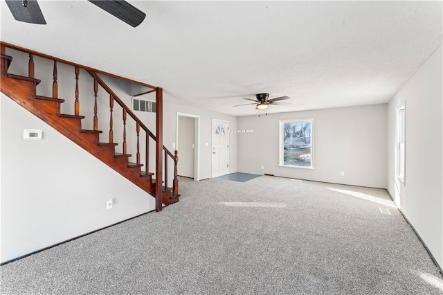 unfurnished living room with ceiling fan and carpet