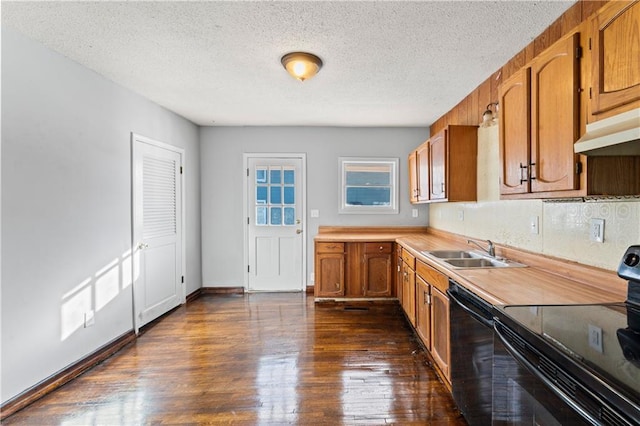 kitchen featuring black appliances, dark hardwood / wood-style floors, sink, and a textured ceiling