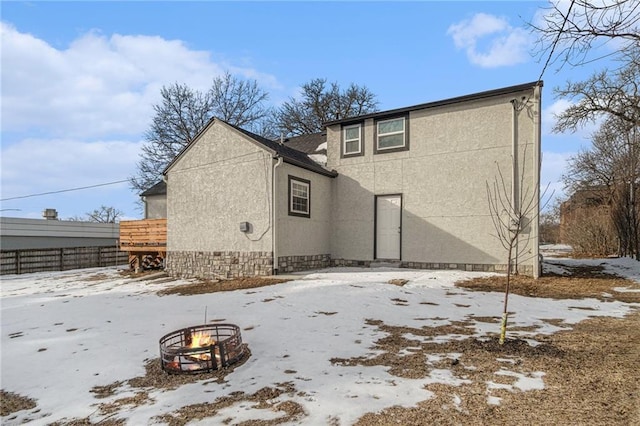 snow covered property featuring an outdoor fire pit