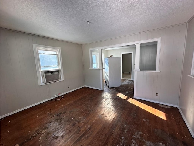 unfurnished room with cooling unit, a textured ceiling, and dark hardwood / wood-style floors