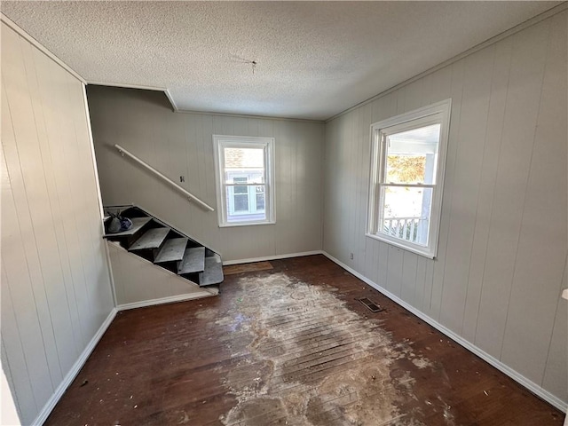 spare room featuring a wealth of natural light and wood walls