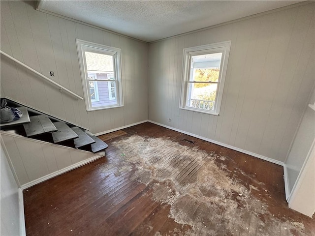 unfurnished room with a textured ceiling and dark hardwood / wood-style floors