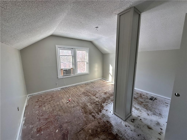 additional living space with a textured ceiling, vaulted ceiling, and cooling unit