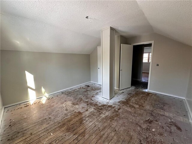 bonus room featuring lofted ceiling and a textured ceiling