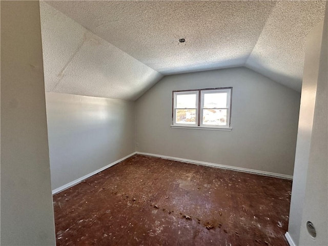 bonus room with lofted ceiling and a textured ceiling