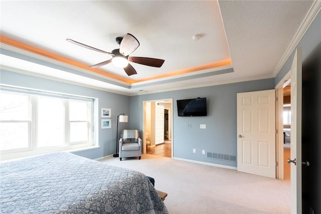 carpeted bedroom featuring crown molding, a raised ceiling, visible vents, ceiling fan, and baseboards