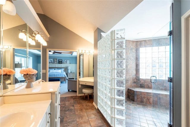 ensuite bathroom with a walk in shower, lofted ceiling, ceiling fan with notable chandelier, vanity, and ensuite bath