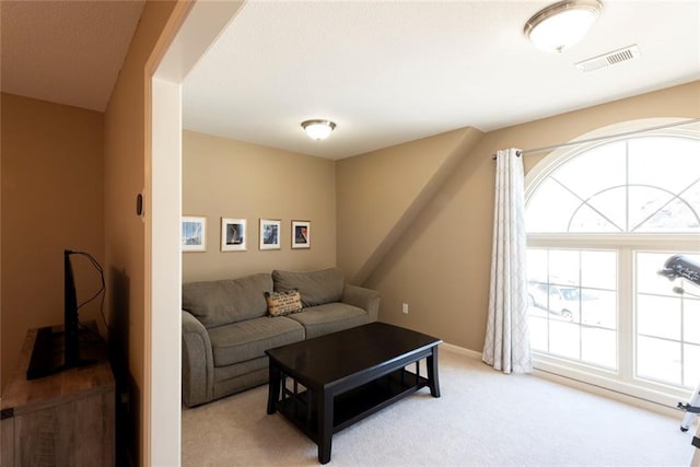 living area featuring visible vents and light carpet