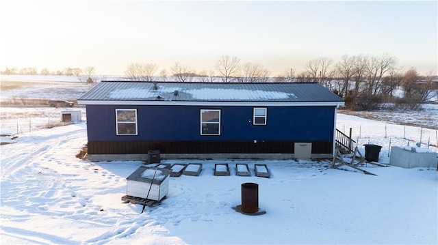 view of snow covered rear of property