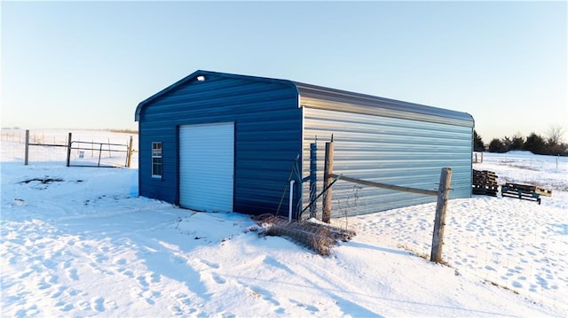 snow covered structure featuring a garage