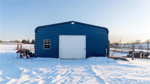 snow covered structure with a garage