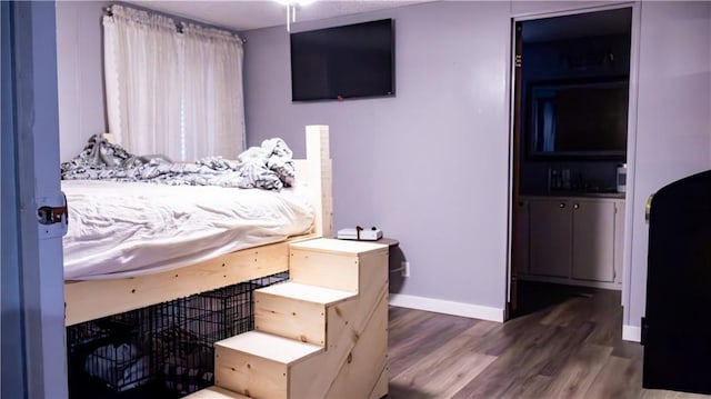 bedroom with dark wood-type flooring