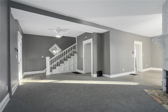 unfurnished living room featuring ceiling fan and carpet