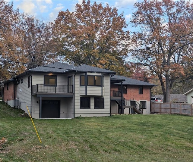 back of property featuring a balcony, a yard, and central AC unit