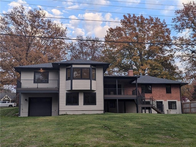 back of property featuring a balcony, a garage, and a lawn