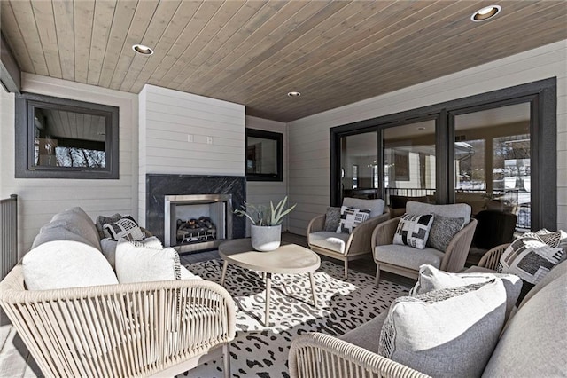 living room with a fireplace, wood ceiling, and wood walls