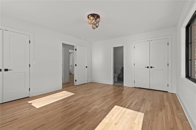 unfurnished bedroom with connected bathroom and light hardwood / wood-style floors