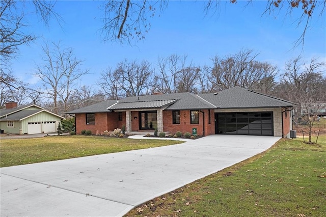 view of front of property with a front yard, central AC unit, driveway, a garage, and brick siding