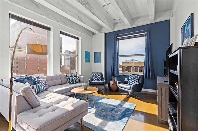 living area featuring concrete floors, beam ceiling, and baseboards