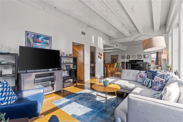 living area with visible vents and wood finished floors