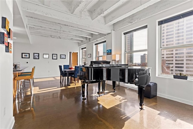 miscellaneous room with baseboards, concrete flooring, and beam ceiling