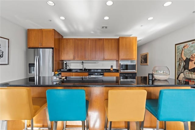 kitchen featuring dark countertops, appliances with stainless steel finishes, and recessed lighting