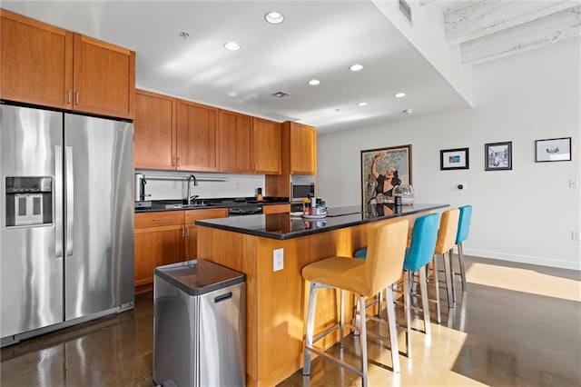 kitchen featuring brown cabinetry, a kitchen island, visible vents, and stainless steel fridge with ice dispenser