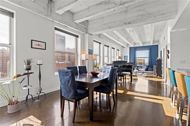 dining space featuring finished concrete flooring and baseboards