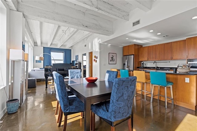 dining room featuring concrete flooring, beamed ceiling, visible vents, and recessed lighting