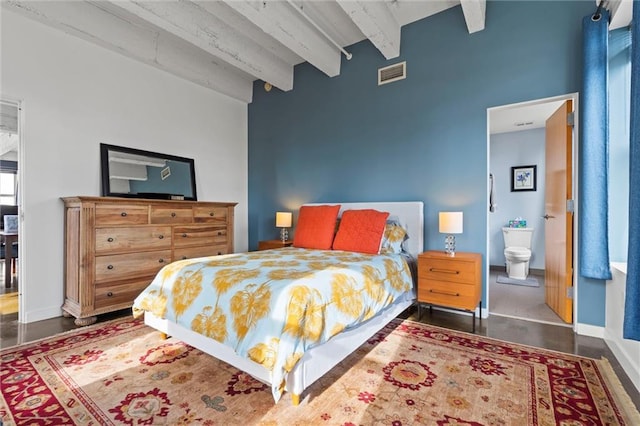 bedroom featuring baseboards, connected bathroom, visible vents, and beamed ceiling