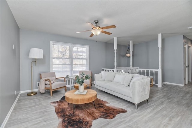 living room featuring ceiling fan and light hardwood / wood-style flooring