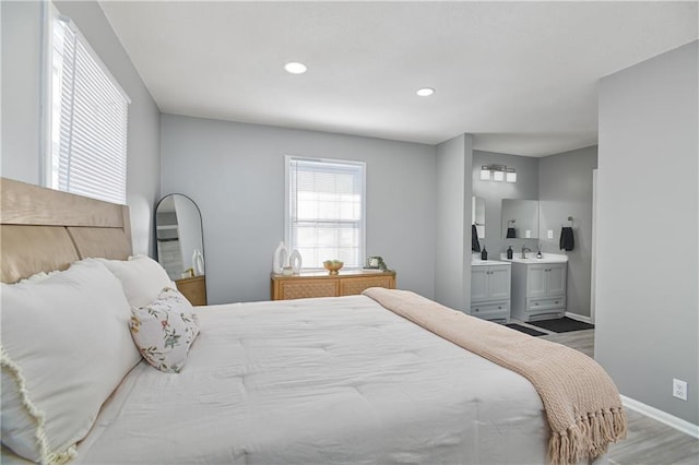 bedroom featuring sink, wood-type flooring, and connected bathroom