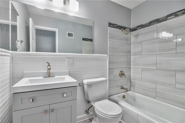 full bathroom with toilet, vanity, and tiled shower / bath