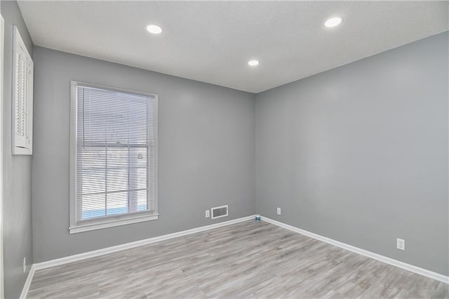 empty room with light hardwood / wood-style flooring