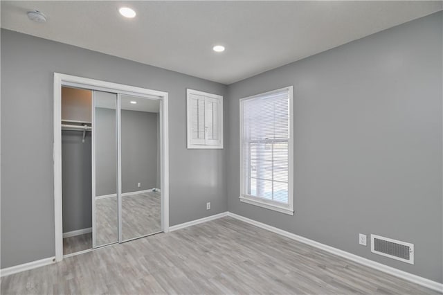 unfurnished bedroom featuring a closet and light hardwood / wood-style floors