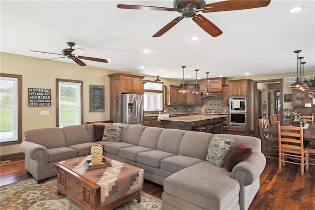 living room with ceiling fan and dark hardwood / wood-style flooring