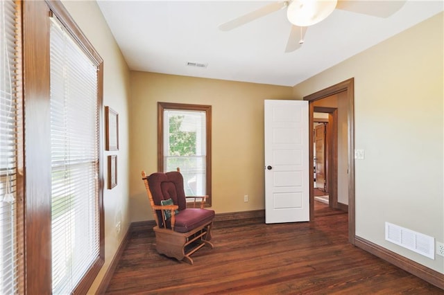 living area featuring dark wood-type flooring and ceiling fan