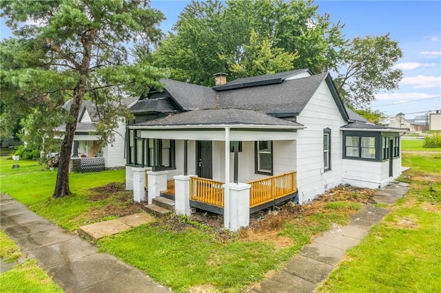 bungalow-style house featuring covered porch and a front lawn