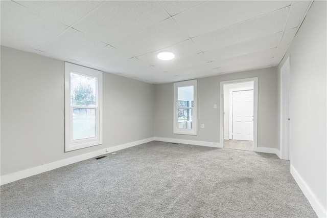 unfurnished room with a paneled ceiling and carpet