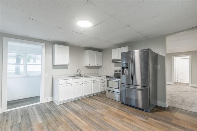 kitchen with appliances with stainless steel finishes, a paneled ceiling, white cabinetry, and sink