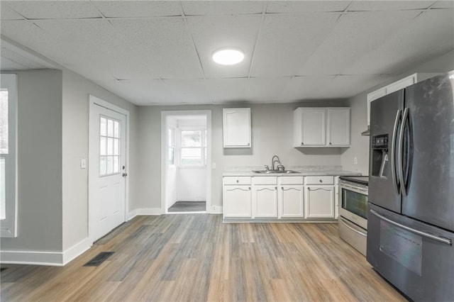 kitchen featuring appliances with stainless steel finishes, a paneled ceiling, white cabinetry, and sink