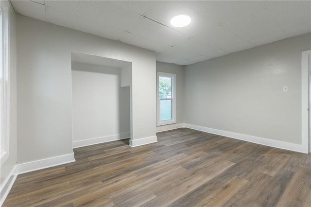 spare room featuring dark hardwood / wood-style floors and a drop ceiling