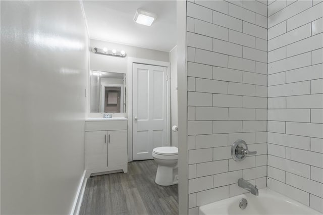 full bathroom with toilet, vanity, tiled shower / bath combo, and hardwood / wood-style flooring