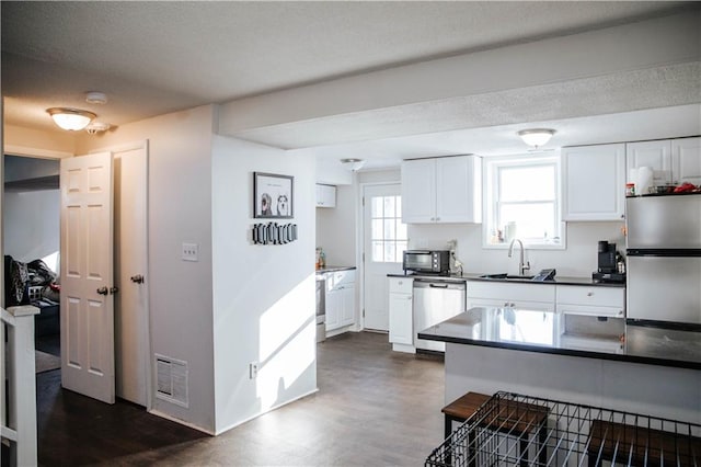 kitchen with sink, white cabinetry, stainless steel appliances, and a textured ceiling