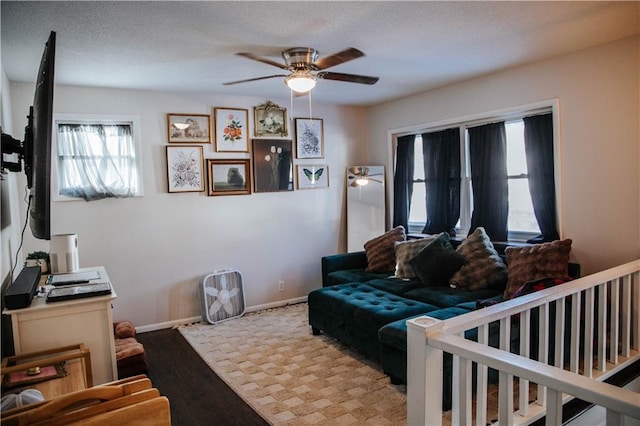 living room with ceiling fan, a textured ceiling, and light hardwood / wood-style floors