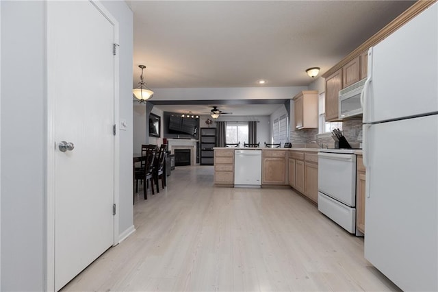 kitchen with pendant lighting, light brown cabinetry, white appliances, and light hardwood / wood-style flooring